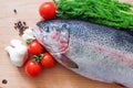 Raw rainbow trout on a cutting board with vegetables and spices Royalty Free Stock Photo