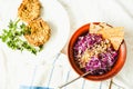 Raw red cabbage salad with seeds andcorn crackers, top view