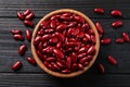 Raw red kidney beans and bowl on dark wooden table, flat lay Royalty Free Stock Photo