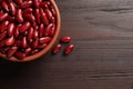 Raw red kidney beans with bowl on wooden table, flat lay. Space for text Royalty Free Stock Photo