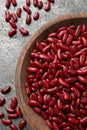 Raw red kidney beans with wooden bowl on grey table, flat lay Royalty Free Stock Photo