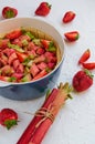 Raw rhubarb strawberry pie ready for cooking in the baking dish on the white kitchen table. Decorated with organic ingredients Royalty Free Stock Photo