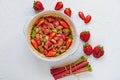 Raw rhubarb strawberry pie ready for cooking in the baking dish on the white kitchen table with fresh ingredients Royalty Free Stock Photo