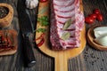 Raw ribs with peppercorns, bay leaves and spices on a cutting board. On a black background Royalty Free Stock Photo