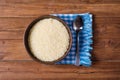 Raw rice in a clay plate and napkin on a wooden table old.