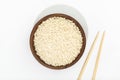 Raw rice in wooden bowl with chopsticks on white background Royalty Free Stock Photo