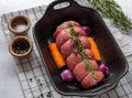 Uncooked roast beef with garnish in roast pan, cooking preparation Royalty Free Stock Photo