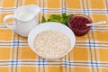 Raw rolled oats, hot milk and red currants on table Royalty Free Stock Photo