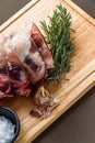 Raw rolled and tied Herdwick Sheep lamb joint with garlic, rosemary and sea salt, portrait Royalty Free Stock Photo