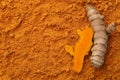 Raw roots on aromatic turmeric powder, top view. Space for text Royalty Free Stock Photo