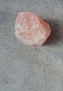 Raw rose quartz crystal close up on gray marble background