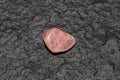 Raw rose quartz isolated on black stone background. Macro shot Royalty Free Stock Photo