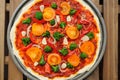 Raw round pizza with yellow cherry tomatoes, onion, garlic and b Royalty Free Stock Photo