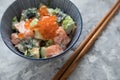 Raw salmon avocado Tatar with dill and Keta caviar in porcelain bowl with wooden chopsticks