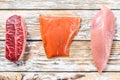 Raw salmon, beef and Turkey. Fresh organic meat. White wooden background. Top view