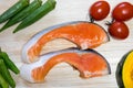 Orange salmon cuts with vegetables around. Royalty Free Stock Photo