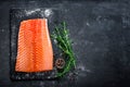 Raw salmon filet on dark slate background, wild atlantic fish, space for text Royalty Free Stock Photo