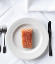 Raw salmon filet on a white plate and linen