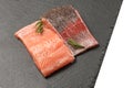 Raw salmon fillet on a dark slate background. Trout fillet with rosemary. Wild atlantic fish