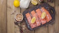 Raw salmon fillet with pepper sweetbread and salt on baking paper rustic theme with copy-space. Flat lay Royalty Free Stock Photo