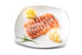 Raw salmon fillet pieces served with spices, lemon, butter and herbs on white plate isolated on white background Royalty Free Stock Photo