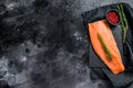 Raw salmon fillet with rosemary and pink pepper. Organic fish. Black background. Top view. Copy space Royalty Free Stock Photo