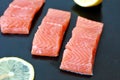 Raw salmon fillet with yellow lemon on black background