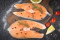 Raw salmon fish fillet and ice for cooked steak seafood - Fresh salmon steak with herbs and spices lemon rosemary tomato on wooden Royalty Free Stock Photo