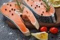 Raw salmon fish fillet and ice for cooked steak seafood - Fresh salmon steak with herbs and spices lemon rosemary tomato on wooden Royalty Free Stock Photo