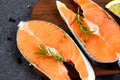 Raw salmon fish fillet and ice for cooked steak seafood - Fresh salmon steak with herbs and spices lemon rosemary on wooden Royalty Free Stock Photo