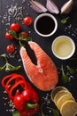 Raw salmon and ingredients on a black board close-up. vertical t Royalty Free Stock Photo