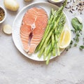 Raw salmon steak with fresh vegetables for garnish Royalty Free Stock Photo