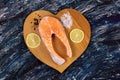 raw salmon steak with ingredients such as lemon  pepper  sea salt on a black Board. flat lay Royalty Free Stock Photo