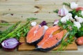 Raw salmon steaks with fresh vegetables and mushrooms on wooden desk Royalty Free Stock Photo