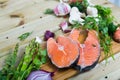 Raw salmon steaks with fresh vegetables and mushrooms on wooden desk Royalty Free Stock Photo