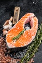 Raw Salmon trout Fish Steak on butcher table with meat cleaver. Black background. Top view Royalty Free Stock Photo