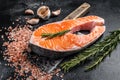 Raw Salmon trout Fish Steak on butcher table with meat cleaver. Black background. Top view Royalty Free Stock Photo