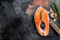 Raw Salmon trout Fish Steak on butcher table with meat cleaver. Black background. Top view. Copy space Royalty Free Stock Photo