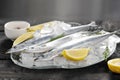 Raw saury on a glass dish in the form of fish with rosemary and lemon Royalty Free Stock Photo