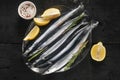 Raw saury on a glass dish in the form of fish with rosemary and lemon Royalty Free Stock Photo