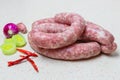 Raw sausage with spices on a light table Royalty Free Stock Photo