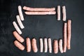 Raw sausages, frame concept, top view with space for text, on black background Royalty Free Stock Photo