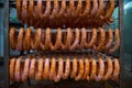 Raw sausages on racks in storage room at meat processing factory Royalty Free Stock Photo