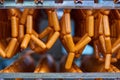 Raw sausages on racks in storage room at meat processing factory Royalty Free Stock Photo