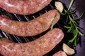 Raw sausages with rosemary twigs and garlic in a cast iron grill pan. Top view Royalty Free Stock Photo