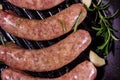 Raw sausages with rosemary twigs and garlic in a cast iron grill pan. Top view Royalty Free Stock Photo