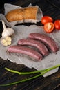 Raw sausages in the skin composition top and side view with vegetables and herbs on a dark tree Royalty Free Stock Photo