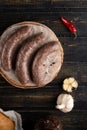 Raw sausages in the skin composition top and side view with vegetables and herbs on a dark tree Royalty Free Stock Photo