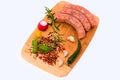 Raw sausages with vegetables on wooden cutting board Royalty Free Stock Photo