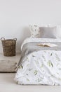 Raw scandinavian style bedroom interior with a bed dressed in natural fabric sheets, pillows and blanket